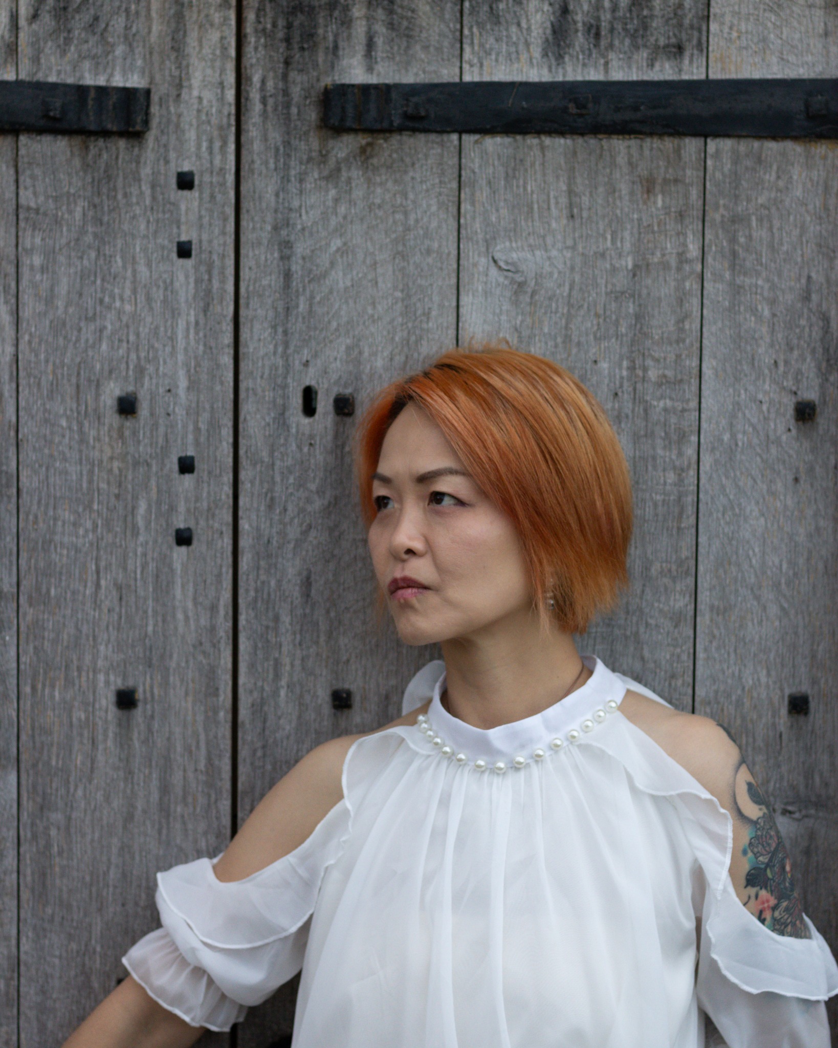 Portrait of a woman beside a wooden doorway