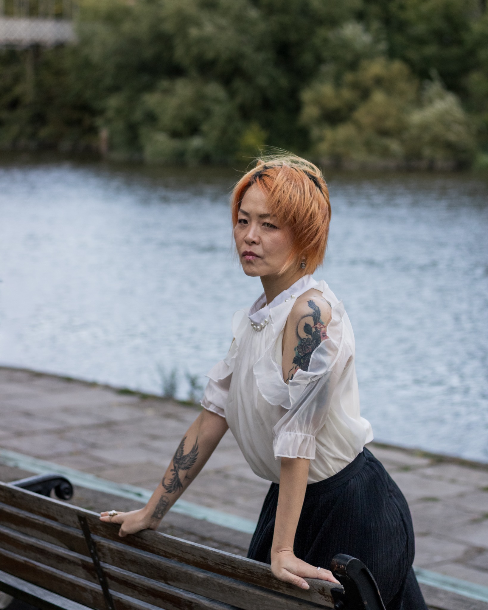 A woman leaning on a bench beside the River Dee